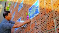 A man places flowers on a wave-shapedtsunami monument for victims of the 2004 tsunami in Ban Nam Khem, in Phang Nga Province, Thailand,  yesterday.