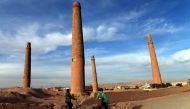 Afghan youths ride their bicycles past the historic minarets of Herat province (AFP) 