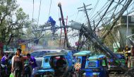 A worker fixes an electric post after it was damaged during Typhoon Nock-ten, in Iriga City, Camarines Sur, yesterday.
