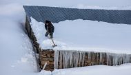 A man shovels snow off a roof due to inclement weather conditions in Van, Turkey on December 27, 2016. Ali ?hsan Öztürk - AA