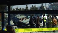 Afghan security personnel inspect a damaged vehicle after a roadside bomb explosion in Kabul, yesterday.