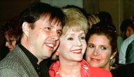 Actress Debbie Reynolds (C) and son, filmmaker Todd Fisher, and daughter, screenwriter Carrie Fisher, arrive at a luncheon hosted by the American Film Institute September 17, 1998. REUTERS/File Photo 