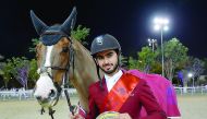 Qatari rider Nasser Al Ghazali, the winner of the  Special two phases, Art. 274.5.6 - 145 cm event, poses for a photograph with his trophy during the Al Rayyan International Show Jumping Championship in Doha yesterday. Pictures by Lotfi Garsi
