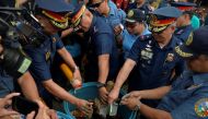 Philippine National Police (PNP) Director General Ronald Dela Rosa (C), along with other police officials, dunks confiscated illegal firecrackers into a tub of water to render them unusable, during an inspection of firecracker shops ahead of new year cele