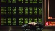 An investor watching stock prices on screens at a securities company in Beijing