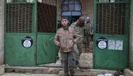 Rebel fighters walk out of a mosque in al-Rai town, northern Aleppo countryside, Syria December 30, 2016. On the gate are seen Islamic State logo stickers. REUTERS/Khalil Ashawi