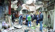 People inspect the scene of the suicide attacks at a bazaar in Baghdad,  yesterday.