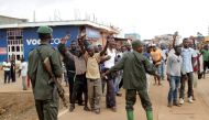 Congolese soldiers stand guard as civilians chant slogans during a protest in the town of Butembo, North Kivu province, Congo August 24, 2016 (REUTERS) 