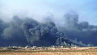 Smoke rises from burning oil wells in Qayyarah, south of Mosul.