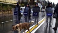 A stray dog walks past Turkish police officer blocking the road close to the site of an armed attack near the Reina night club, one of the Istanbul's most exclusive party spots, early on January 1, 2017 after at least one gunmen went on a shooting rampage