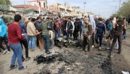 BAGDAD, IRAQ - JANUARY 2: People gather around remains of the wrecked vehicle following a blast, caused by a bomb-laden vehicle, at 55th Square in Sadr Region of Baghdad, Iraq on January 2, 2017. Scores of casualties reported. (Murtadha Sudani - Anadolu A