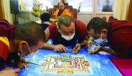 Tibetan Spiritual Leader The Dalai Lama looks on as Buddhist monks work on a traditional painting during a special religious prayer during the Kalachakra event at Bodhgaya, yesterday.