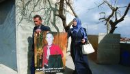 Rajaa and Yousri, parents of Abdul Fatah Al Sharif (portrait) head out into the streets in the West Bank town of Hebron.