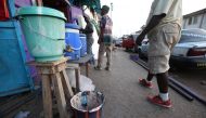A chlorinated water bucket to help curb the spread of Ebola virus is placed on a street corner in downtown Monrovia, Liberia, April 1, 2016 (EPA / AHMED JALLANZO)