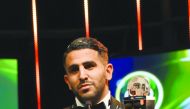 Algerian Riyad Mahrez speaks while holding trophy after being crowned African Footballer of the Year in Abuja, Nigeria on Thursday.