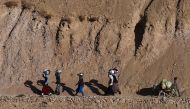 In this photograph taken on November 5, 2016, a group of Afghan Hazara women carry washed utensils as they walk home in the Yakawlang District of Bamiyan Province.  AFP / Wakil KOHSAR