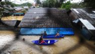 This photo taken on January 2, 2017 shows people navigating floodwaters by boat after heavy rains in Sungai Kolok district in the southern Thai province of Narathiwat. / AFP / MADAREE TOHLALA.