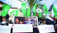 Palestinian children part in a protest against ongoing electricity shortages, with the flags of Islamist movement Hamas waving behind, in Gaza City on January 10, 2017. The signs in Arabic read (R-L): 