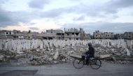 A Syrian man rides a bicycle in the rebel-held town of Douma, on the eastern outskirts of the capital Damascus, on January 9, 2017. AFP / Abd Doumany
