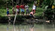 This picture taken on December 22, 2016 shows a group of Indonesian children trying to catch fish on the banks of one of the tributaries of the Ciliwung river in the Indonesian capital Jakarta. AFP / GOH CHAI HIN