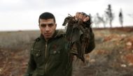 Ahmad Najjar, a 27 year-old Free Syrian Army fighter, holds a torn camouflage rags he said had clothed one of two colleagues recently blown up trying to dismantle explosives planted by the Islamic State fighters, on the outskirts of the northern Syrian to