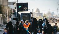 Iraqi women and children are pictured in Mosul's al-Sahiroun neighbourhood on January 12, 2017, as they flee their homes during a military operation by Iraqi security forces against IS militants.  AFP / Dimitar DILKOFF
