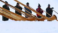 Alphorn players blow their instruments as snow falls on the Fellhorn mountain near Oberstdorf, southern Germany, during a ceremony to inaugurate a new chairlift on January 13, 2017. / AFP / dpa / Karl-Josef Hildenbrand
