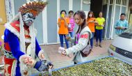 A customer buys a packet of dried river shells from Mak Sobin (L) in Phnom Penh on January 14, 2017. Mak Sobin, 25, who has been selling dried river shells as a snack for seven years, started wearing the opera costume 1.5 months ago as an attempt to attra