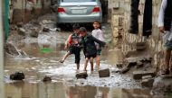 FILE PHOTO: Yemeni children play in water puddles following heavy rainfall in the outskirts of the Yemeni capital, Sanaa on July 31, 2016 (AFP / MOHAMMED HUWAIS) 
