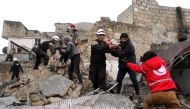 Syrian Civil Defence volunteers, also knowns as the White Helmets, rescue children from a damaged building following a reported airstrike that targeted the Idlib bus station on January 18, 2017. AFP / Omar Haj Kadour