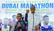 Ethiopian runners Worknesh Degefa (left) and Tamirat Tola celebrate on the podium after winning the Dubai marathon yesterday. 
