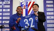 Argentine striker Carlos Tevez (L) poses with a jersey of his new club Shanghai Shenhua during a press conference in Shanghai on January 21, 2017. Tevez held his first press conference for his new club Shanghai Shenhua, which reportedly has made him the w