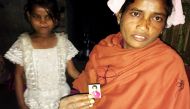 Rukmani Naik poses with a picture of her 14-year-old daughter who left their home in the Diana Tea Estate in West Bengal, India, to work in another city. January 12, 2017 (Reuters)