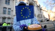 A demonstrator holds a cake with an European Union (EU) flag in it following the judgement in a case to decide whether or not parliamentary approval is needed before the government can begin Brexit negotiations, outside the Supreme Court, opposite the Hou