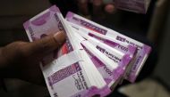 A cashier displays the new 2000 Indian rupee banknotes inside a bank in Jammu, India. (Reuters)