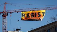 Protesters unfurl a banner atop a crane at the construction site of the former Washington Post office building, January 25, 2017 in Washington, DC. The protestors are with the Greenpeace organization. Drew Angerer/Getty Images/AFP