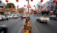 A man sits under lanterns and decorations on a street ahead of the Chinese Lunar New Year in Chinatown Yangon, Myanmar January 23, 2017. REUTERS/Soe Zeya Tun