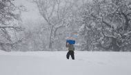 An Afghan man caries gas cylinder on his shoulder on the snowy day on the outskirts of Kabul, Afghanistan January 24, 2017. REUTERS/ Omar Sobhani