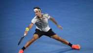 Switzerland's Roger Federer hits a return against compatriot Stanislas Wawrinka during their men's singles semi-final match on day 11 of the Australian Open tennis tournament in Melbourne on January 26, 2017. (AFP / SAEED KHAN)
