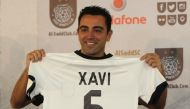 This file photo taken on June 11, 2015 shows Barcelona legend Xavi Hernandez posing for a photo with his new Al-Sadd shirt after signing a two-year contract with the Qatari team in Doha. Barcelona great Xavi Hernandez has agreed a year's extension to his 