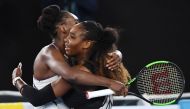 Serena Williams of the US (R) hugs Venus Williams of the US after winning the women's singles final on day 13 of the Australian Open tennis tournament in Melbourne on January 28, 2017. AFP / WILLIAM WEST