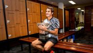 Switzerland's Roger Federer sits with the trophy after winning the Men's singles final at the Australian Open tennis tournament in Melbourne, Australia in this handout image taken January 30, 2017. (Fiona Hamilton/Courtesy of Tennis Australia/Handout via 