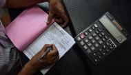 An Indian shopkeeper prepares a bill for a customer at his shop in New Delhi on August 3, 2016 (AFP / SAJJAD HUSSAIN) 