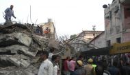Indian residents stand near an under-construction building which collapsed in Kanpur on February 1, 2017. Indian police and army personnel are carrying out a resuce operation after an under-construction building collapsed in the state of Uttar Pradesh. Tw