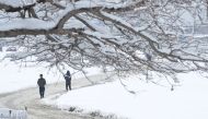 Afghan men make their way down a snow-covered street in Kabul on February 5, 2017. Avalanches and freezing weather have killed more than 20 people in different areas of Afghanistan, officials said on February 4, as rescuers worked to save scores still tra