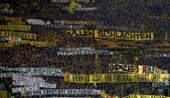 Borussia Dortmund's fans hold banners and cheer during the game. REUTERS/Wolfgang Rattay 
