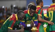Cameroon's goalkeeper Fabrice Ondoa (C) and Cameroon's forward Vincent Aboubakar (L) react to the winner's trophy after Cameroon beat Egypt 2-1 in the 2017 Africa Cup of Nations final football match between Egypt and Cameroon at the Stade de l'Amitie Sino