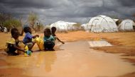 (FILES) This file photo taken on October 16, 2011 shows Somali boys fetching water from a puddle that formed after rain at the IFO-2 complex of the sprawling Dadaab refugee complex in Kenya.  AFP / Tony KARUMBA
