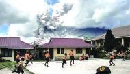 Elementary schoolchildren play outside of their classrooms as mount Sinabung spews thick volcanic ash as seen from Karo, yesterday.