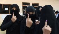 Muslim women show their fingers, which were marked after they cast their votes, at a polling station in Muzaffarnagar in Uttar Pradesh on February 11, 2017. AFP / Prakash SINGH